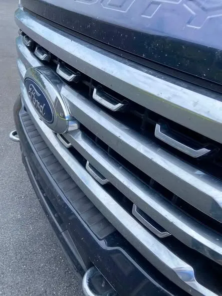 Chrome grille and bumper of a blue Ford after washing