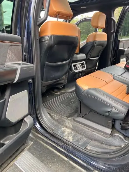 Tan leather rear seats inside a pickup truck after a detail